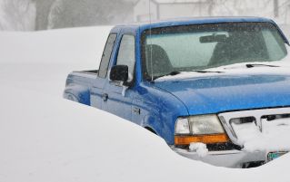 A blue pickup truck buried in snow during a severe winter storm in Lusk, Wyoming.